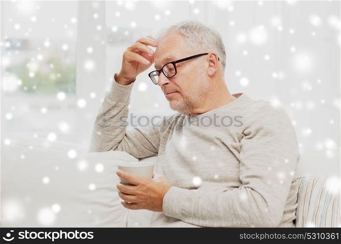 old age and people concept - senior man with cup of tea at home over snow. senior man with cup of tea at home