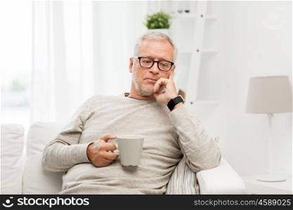 old age, drink and people concept - senior man with cup of tea at home