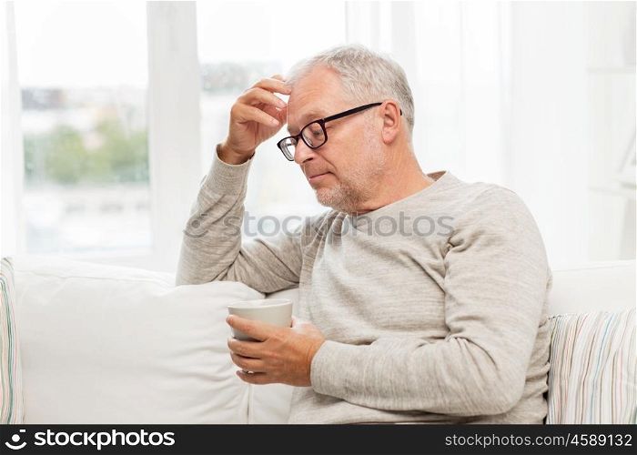 old age, drink and people concept - senior man with cup of tea at home