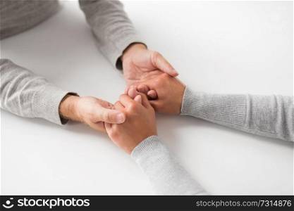 old age, family, care and support concept - close up of young woman holding senior man hands. close up of young woman holding senior man hands
