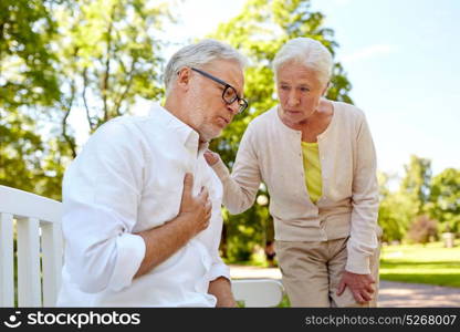 old age, health problem and people concept - senior man feeling sick at summer park. senior man feeling sick at summer park