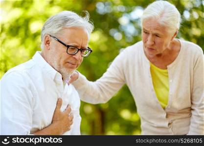 old age, health problem and people concept - senior man feeling sick at summer park. senior man feeling sick at summer park
