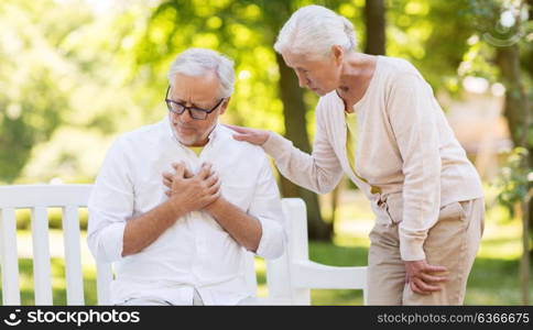 old age, health problem and people concept - senior man feeling sick at summer park. senior man feeling sick at summer park