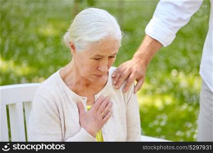 old age, health problem and people concept - senior woman feeling sick at summer park. senior woman feeling sick at summer park