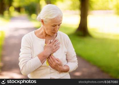 old age, health problem and people concept - senior woman feeling sick at summer park. senior woman feeling sick at summer park