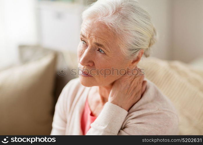 old age, health problem and people concept - senior woman suffering from neck pain at home. senior woman suffering from neck pain at home