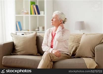 old age, health problem and people concept - senior woman suffering from neck pain at home. senior woman suffering from neck pain at home