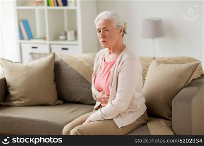 old age, health problem and people concept - senior woman suffering from stomach ache at home. senior woman suffering from stomach ache at home
