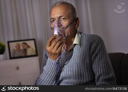 Old age man wearing oxygen mask at home