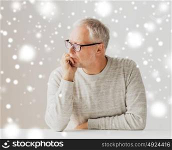old age, problem and people concept - close up of senior man in glasses thinking over snow. close up of senior man in glasses thinking