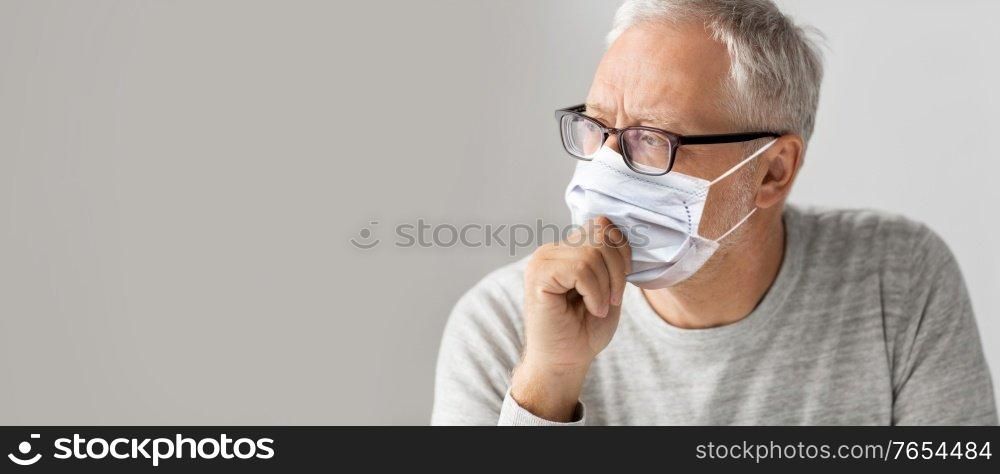 old age, problem and people concept - close up of senior man in glasses wearing face protective medical mask for protection from virus disease over grey background. close up of senior man in glasses and medical mask