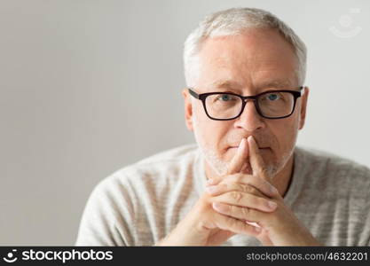 old age, problem and people concept - close up of senior man in glasses thinking