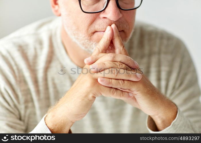 old age, problem and people concept - close up of senior man in glasses thinking