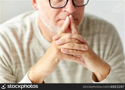 old age, problem and people concept - close up of senior man in glasses thinking