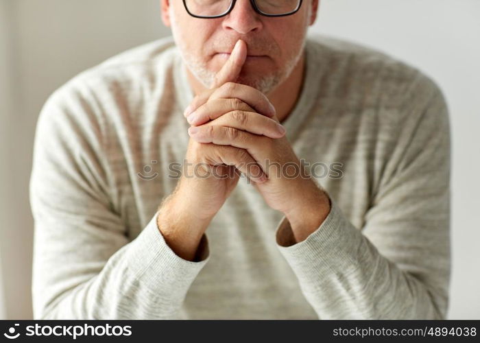 old age, problem and people concept - close up of senior man in glasses thinking