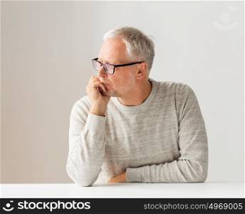 old age, problem and people concept - close up of senior man in glasses thinking. close up of senior man in glasses thinking