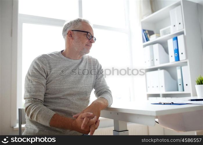 old age, problem, healthcare and people concept - sad senior man sitting at table at medical office