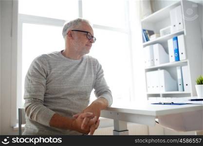 old age, problem, healthcare and people concept - sad senior man sitting at table at medical office