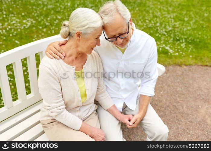 old age, relationship and people concept - happy senior couple hugging in city park. happy senior couple hugging in city park