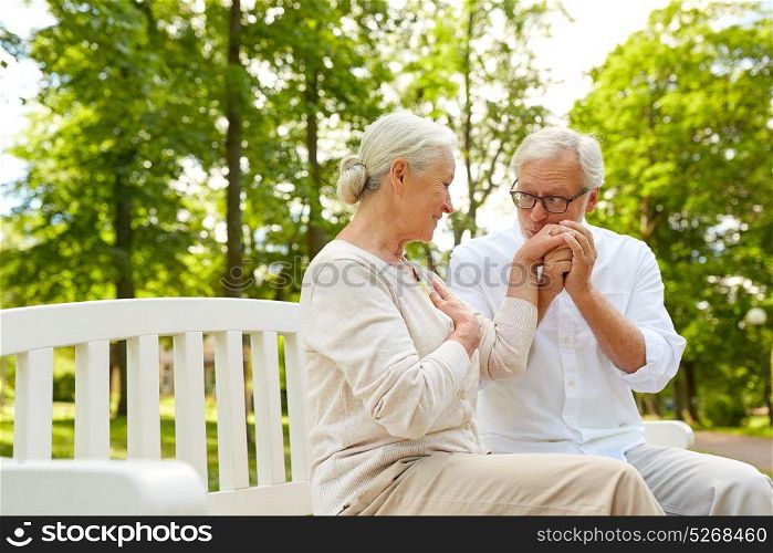old age, relationship and people concept - happy senior couple hugging in city park. happy senior couple hugging in city park