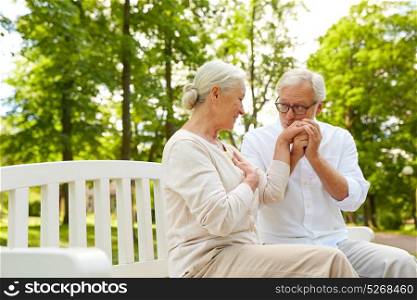 old age, relationship and people concept - happy senior couple hugging in city park. happy senior couple hugging in city park