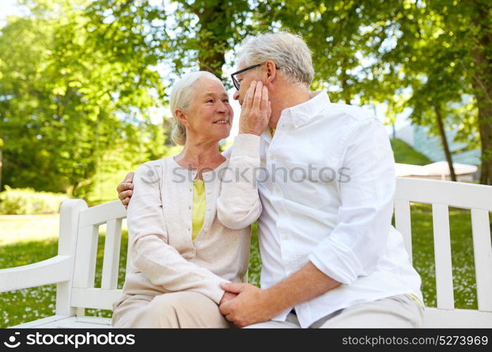 old age, relationship and people concept - happy senior couple hugging in city park. happy senior couple hugging in city park