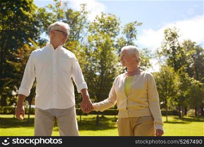 old age, relationship and people concept - happy senior couple walking at summer city park. happy senior couple walking at summer city park