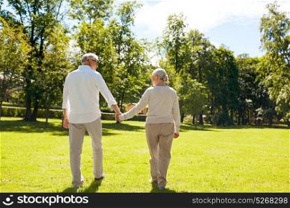 old age, relationship and people concept - happy senior couple walking at summer city park. happy senior couple walking at summer city park