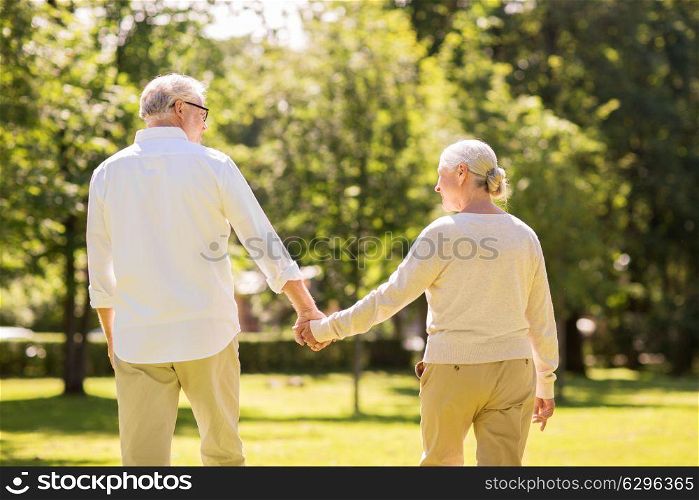 old age, relationship and people concept - happy senior couple walking at summer park. happy senior couple walking at summer park