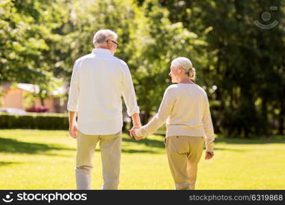 old age, relationship and people concept - happy senior couple walking at summer park. happy senior couple walking at summer park