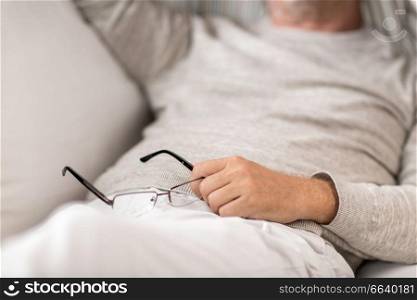 old age, rest, comfort and people concept - close up of senior man with glasses sleeping on sofa. close up of senior man with glasses sleeping