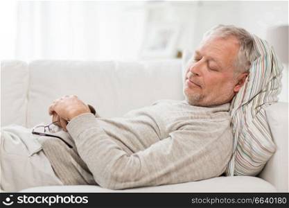 old age, rest, comfort and people concept - senior man sleeping on sofa at home. senior man sleeping on sofa at home
