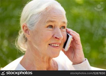 old age, retirement and people concept - close up of happy senior woman calling on smartphone in summer. happy senior woman calling on smartphone in summer