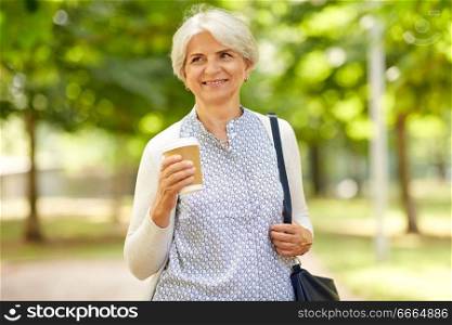 old age, retirement and people concept - close up of happy senior woman drinking takeaway coffee at summer park. senior woman drinking takeaway coffee at park