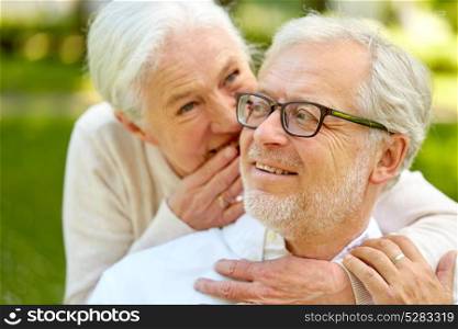 old age, retirement and people concept - close up of happy senior couple whispering outdoors. close up of senior couple whispering outdoors