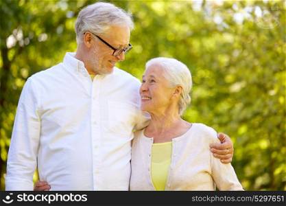 old age, retirement and people concept - happy senior couple hugging at summer park. happy senior couple hugging at summer park