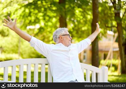 old age, retirement and people concept - happy senior man in glasses sitting on bench at summer park. happy senior man sitting on bench at summer park