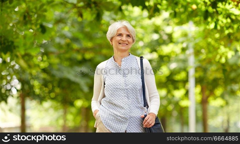 old age, retirement and people concept - happy senior woman with handbag at summer park. happy senior woman with handbag at summer park