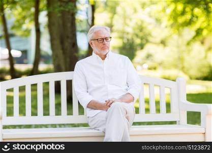 old age, retirement and people concept - sad senior man in glasses at summer park. sad senior man at summer park
