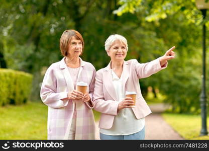 old age, retirement and people concept - two senior women or friends drinking coffee at summer park. senior women or friends drinking coffee at park