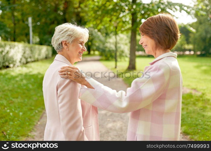 old age, retirement and people concept - two senior women or friends talking at summer park. senior women or friends talking at summer park