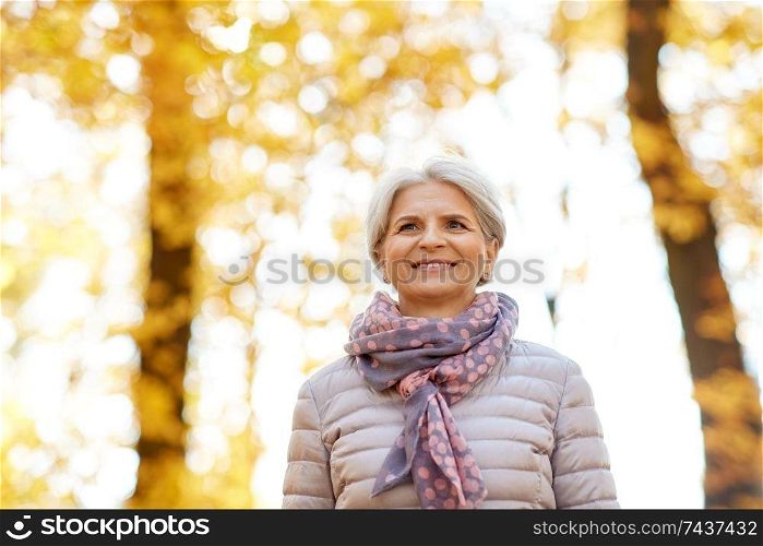 old age, retirement and season concept - portrait of happy senior woman at autumn park. portrait of happy senior woman at autumn park