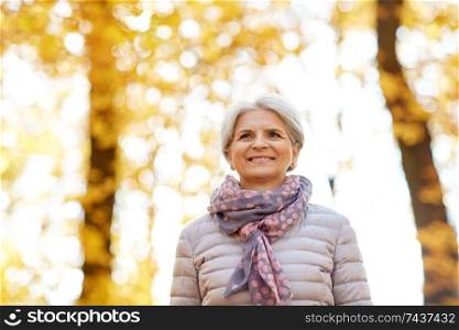 old age, retirement and season concept - portrait of happy senior woman at autumn park. portrait of happy senior woman at autumn park
