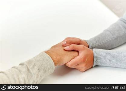 old age, support, charity, care and people concept - close up of senior man and young woman holding hands. close up of old man and young woman holding hands
