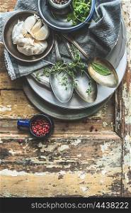 Old aged cutlery and rustic plates with flavoring on wooden background, top view