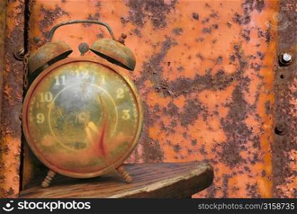 Old alarm clock and rusty red metal