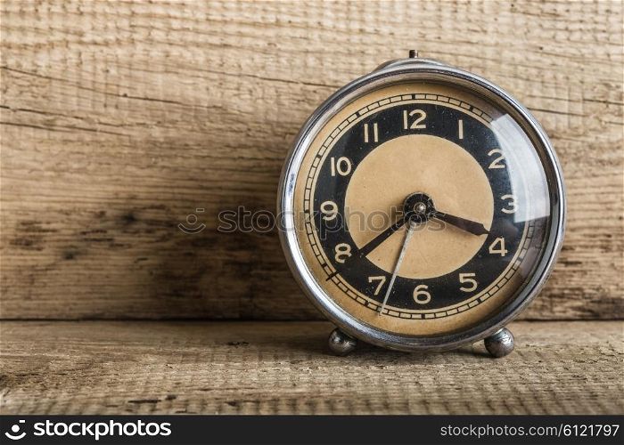 Old alarm clock on a wooden shelf