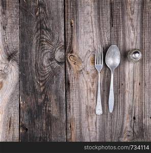 old aluminum false and fork on a gray wooden table, top view, copy space