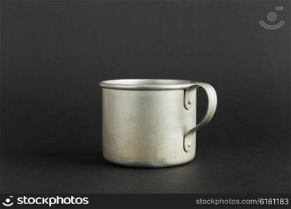 Old aluminum mug on a black background