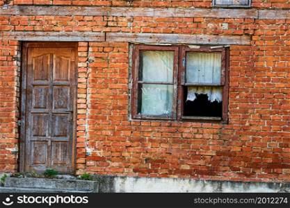 Old and abandoned brick house with broken windows.